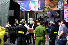 Cảnh sát kiểm tra, khám xét và đưa các kiện hàng lên xe tại cửa hàng điện thoại Nhật Cường mobile ở 33 Lý Quốc Sư, Hà Nội. (Ảnh: Doãn Tấn/TTXVN)