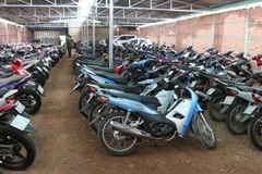 Lực lượng chức năng kiểm tra số xe máy trong các kho hàng của cơ sở cầm đồ. (Ảnh: Đậu Tất Thành/TTXVN)