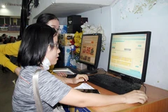 Hành khách đặt mua vé qua website ngành đường sắt tại ga Sài Gòn. (Ảnh: Tiến Lực/TTXVN)