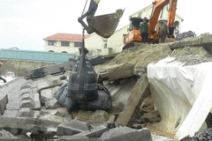 Phần thân kè, đoạn tiếp giáp với nước biển được gia cường bằng túi cát lớn. (Ảnh: Hữu Trung/TTXVN)