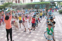 Trẻ từ 3-6 tuổi sẽ thực hiện các bài tập thể dục với dụng cụ để hỗ trợ phát triển thể lực. (Ảnh: Lê Thúy Hằng/TTXVN)