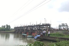 Lực lượng chức năng tìm kiếm thi thể các nạn nhân. (Ảnh: TTXVN)