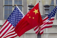 Quốc kỳ Trung Quốc (giữa) và quốc kỳ Mỹ. (Ảnh: Getty Images/ TTXVN)