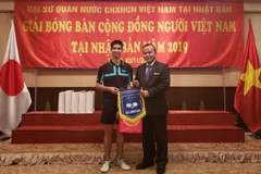 Đại sứ Việt Nam tại Nhật Bản Vũ Hồng Nam trao giải cho vận động viên vô địch nội dung đơn nam. (Ảnh: Thanh Tùng/TTXVN)