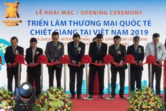 Đại diện Ban tổ chức cắt băng khai mạc triển lãm. (Ảnh: Mỹ Phương/TTXVN) 