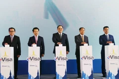 Phó Thủ tướng Lào Sonexay Siphandone (giữa) và các đại biểu nhấn nút khai trương. (Ảnh: Xuân Tú/TTXVN)