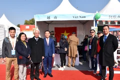 Đại sứ Phạm Sao Mai (thứ 3 bên trái) cùng phu nhân và tập thể cán bộ Đại sứ quán tại gian hàng Việt Nam. (Ảnh: Lương Anh Tuấn/TTXVN)