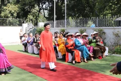 Đại sứ Phạm Sanh Châu trình diễn áo dài nam. (Ảnh: Huy Lê/Vietnam+)