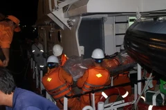 Đưa thi thể Thuyền phó Lương Văn Quỳnh về bờ. (Ảnh: Đoàn Mạnh Dương/TTXVN)