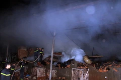 Lực lượng Cảnh sát Phòng cháy chữa cháy nỗ lực phun nước dập tắt đám cháy. (Ảnh: Ngọc Minh/TTXVN)