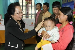 Phó Chủ tịch nước Nguyễn Thị Doan tặng quà cho các gia định bị thiệt hại nặng do bão lụt ở xã Gio Mỹ, huyện Gio Linh. (Ảnh: Hồ Cầu/TTXVN)