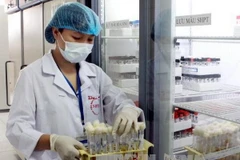 Nhân viên y tế kiểm tra các sinh phẩm được bảo quản tại Ngân hàng gen vi sinh vật - Bệnh viện Bệnh Nhiệt đới Trung ương. (Ảnh: Dương Ngọc/TTXVN)
