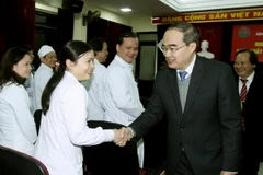 Chủ tịch Ủy ban Trung ương Mặt trận Tổ quốc Việt Nam Nguyễn Thiện Nhân với bác sỹ, nhân viên y tế Bệnh viện Phổi Trung ương. (Ảnh: Nguyễn Dân/TTXVN)