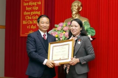 Phó Tổng Giám đốc TTXVN Lê Duy Truyền trao Kỷ niệm chương “Vì sự nghiệp thông tấn” cho Phó Trưởng Ban Chỉ đạo Tây Bắc Hoàng Thị Hạnh. (Ảnh: Thế Duyệt/TTXVN)
