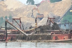Lợi dụng “tấm bùa” nạo vét, doanh nghiệp đã ngang nhiên sử dụng tàu hút cát công suất lớn để “rút ruột” lòng sông Hồng. (Ảnh: PV/Vietnam+)