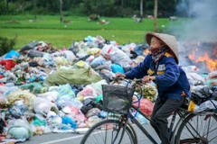 Người dân Thanh Trì khốn khổ vì rác thải tràn ra đường. (Ảnh: PV/Vietnam+)