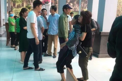 Mẹ nạn nhân Tuấn không thể đứng vững khi vào nhận dạng thi thể con trai mình. (Ảnh: Vietnam+)