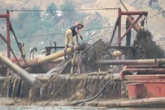 Lợi dụng “tấm bùa” nạo vét, doanh nghiệp đã ngang nhiên sử dụng tàu hút cát công suất lớn để “rút ruột” lòng sông Hồng. (Ảnh: PV/Vietnam+)