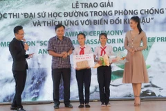 Ông Nguyễn Hoàng Hiệp, Thứ trưởng Bộ Nông nghiệp và Phát triển nông thôn, cùng Hoa hậu Việt Nam 2018 Trần Tiểu Vy trao giải cho các em học sinh giành giải đặc biệt. (Ảnh: UNDP)