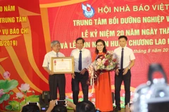 Nhà báo Thuận Hữu, Chủ tịch Hội Nhà báo Việt Nam (thứ 2 bên trái) trao tặng Huân chương Lao động hạng Nhì cho Trung tâm Bồi dưỡng nghiệp vụ báo chí. (Ảnh: H.V/Vietnam+)