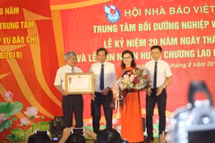 Nhà báo Thuận Hữu, Chủ tịch Hội Nhà báo Việt Nam (thứ 2 bên trái) trao tặng Huân chương Lao động hạng Nhì cho Trung tâm Bồi dưỡng nghiệp vụ báo chí. (Ảnh: H.V/Vietnam+)
