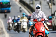 Khi ra đường trong những ngày nhiệt độ cao kỷ lục, người dân cần áp dụng những biện pháp như mặc quần áo chống nắng để bảo vệ làn da. (Ảnh: Thành Đạt/TTXVN)