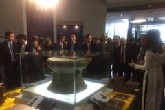 Các đại biểu tham quan trống đồng Cổ Loa, niên đại văn hóa Đông Sơn cách ngày nay 2.500-2.000 năm. (Ảnh: Đinh Thuận/TTXVN)