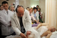 Phó ​giáo sư, ​tiến sỹ Nguyễn Hữu Thành, Giám đốc Bệnh viện châm cứu Trung ương trực tiếp châm cứu cho bệnh nhân người Nga. (Ảnh: Duy Trinh/Vietnam+)
