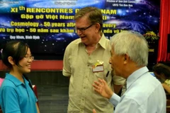 Giáo sư George F. Smoot (giữa) giao lưu cùng học sinh Đinh Thị Hương Thảo, Huy chương vàng Olympic quốc tế môn Vật lý (trái). (Ảnh: Quốc Dũng/TTXVN)