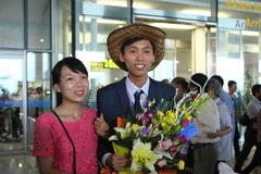 Nguyễn Thế Hoàn, người đoạt huy chương Vàng Olympic Toán quốc tế được chào đón trong vòng tay của người thân cùng các bạn tại Sân bay Quốc tế Nội Bài. (Ảnh: Quý Trung/TTXVN)