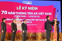 Thủ tướng Nguyễn Tấn Dũng gắn Huân chương Độc lập hạng Nhất lên Cờ truyền thống của Thông tấn xã Việt Nam. (Ảnh: Đức Tám/TTXVN)