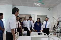 Bộ trưởng Nguyễn Thị Kim Tiến (thứ 2 từ phải) và các đại biểu tham quan bệnh viện. (Ảnh: Thái Hùng/TTXVN)