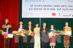 Khen thưởng các sinh viên Lào học tập xuất sắc. (Ảnh: Phạm Kiên/TTXVN)