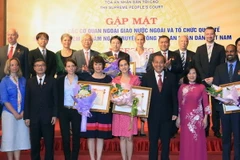 Chánh án Tòa án nhân dân tối cao Trương Hòa Bình trao tặng kỷ niệm chương cho các cá nhân tiêu biểu. (Ảnh: Doãn Tấn/TTXVN)