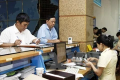 Nhận lương hưu tại bưu điện. (Nguồn: TTXVN)