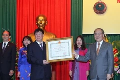 Chủ tịch Quốc hội Nguyễn Sinh Hùng trao tặng Huân chương Độc lập hạng Nhì cho ngành Kho bạc Nhà nước. (Ảnh: Nhan Sáng/TTXVN)