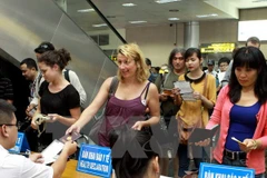 Kiểm tra tờ khai y tế của khách nhập cảnh. (Ảnh: Dương Ngọc/TTXVN)