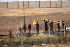Binh sỹ người Kurd giương cờ sau khi chiếm được cửa khẩu Akcakale trên biên giới Syria - Thổ Nhĩ Kỳ ngày 15/6. (Nguồn: AFP/TTXVN) 
