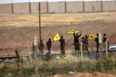 Binh sỹ người Kurd giương cờ sau khi chiếm được cửa khẩu Akcakale trên biên giới Syria - Thổ Nhĩ Kỳ ngày 15/6. (Nguồn: AFP/TTXVN) 