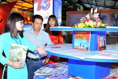 Khách tham quan tại gian hàng các ấn phẩm của TTXVN. (Ảnh: Minh Đức/TTXVN)