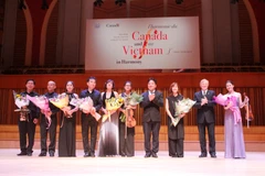 Đại sứ Canada tại Việt Nam David Devine tặng hoa cho các nghệ sỹ. (Ảnh: Hữu Đức/Vietnam+)