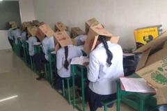 Các sinh viên phải đội thùng carton lên đầu khi làm bài thi.