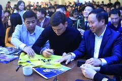 Thủ môn Đặng Văn Lâm ký tặng áo cho người hâm mộ. (Ảnh: Hồng Quân/TTXVN)