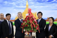 Đại biện Nguyễn Thanh Tùng chúc mừng Phó Trưởng Ban Đối ngoại Trung ương Lào Somphone Sichaleun. (Ảnh: Phạm Kiên/TTXVN)