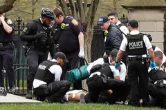 Lực lượng an ninh đưa người đàn ông tự thiêu tới bệnh viện. (Ảnh: Reuters)