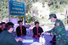 Các chiến sỹ Trạm kiểm soát, Đồn Biên phòng Pa Ủ ở huyện Mường Tè, tỉnh Lai Châu tuyên truyền, phát khẩu trang phòng, chống dịch COVID-19 cho người dân. (Ảnh: Việt Hoàng/TTXVN)