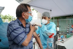 Tiêm vaccine phòng COVID-19 cho người lớn tuổi trên xe lưu động. (Ảnh: Thu Hương/TTXVN)