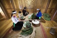 Gia đình quây quần gói bánh chưng, bánh ống trên nếp nhà sàn trong những ngày lễ, Tết là một nét đẹp văn hóa riêng có của người Mường tỉnh Hòa Bình. (Ảnh: Trọng Đạt/TTXVN)