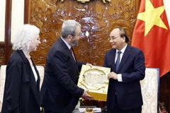 Chủ tịch nước Nguyễn Xuân Phúc trao quà lưu niệm tặng nguyên Thủ tướng Israel Ehud Barak. (Ảnh: Thống Nhất/TTXVN)