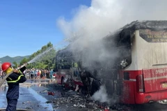 Lực lượng Phòng cháy chữa cháy nỗ lực dập lửa trên chiếc xe biển kiểm sát 99B-018.94. (Ảnh: TTXVN phát)